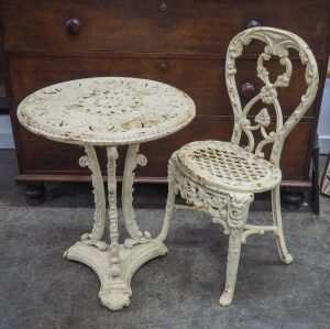 An antique English cream painted cast iron garden occasional table with acanthus supports and tri-form base; together with a balloon back cast iron garden chair with floral decorated frieze and pierced seat, 19th century, (2 items), the table 62cm high, 5