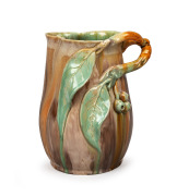 REMUED green and brown glazed pottery jug with orange highlights, adorned with branch handle, gumnuts and leaves, incised "Remued, Hand Made, 189M", 21.5cm high