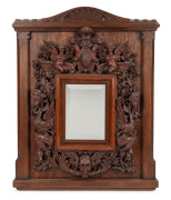 ROBERT PRENZEL&nbsp;(1866-1941), mirror frame, sumptuously carved with grotesques, angels, grapes and foliate motifs, crested by a&nbsp;shield dated 1889. A rare and early example, signed lower right "ROBERT PRENZEL", 51 x 41cm&nbsp; overall. See full page illustration,