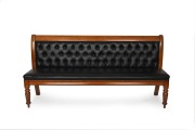 An antique Colonial Australian cedar settle upholstered in diamond button back black leather, Melbourne origin, 19th century, 97cm high, 195cm wide, 50cm deep