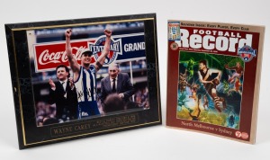 The 1996 Grand Final Football Record together with a 33 x 26.5cm framed photograph signed by the winning captain Wayne Carey of North Melbourne. Carey played an integral part in North Melbourne's 1996 win, cementing his reputation as one of the greatest p
