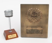 1956 Olympic Torch replica on wooden presentation stand, height 16.5cm, with plaque that reads 'TO ROSS OAKLEY - IN APPRECIATION VICTORIAN OLYMPIC COUNCIL'. Accompanied by a 16 x 20cm bronze plaque featuring the Australian coat of arms and Olympic symbols