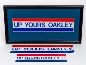 FITZROY/FOOTSCRAY PROPOSED MERGER: Ross Oakley's original personal 'UP YOURS OAKLEY' bumper sticker, framed and glazed, 18 x 35cm overall, together with additional original sticker and 'UP YOURS OAKLEY' bookmark. Oakley's controversial 1989 proposal to so