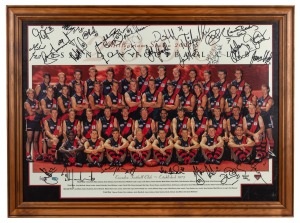 ESSENDON FOOTBALL CLUB "Millennium Season 2000" full team official photograph with 27 original signatures including Kevin Sheedy, Matthew Lloyd, Michael Long, James Hird and Dustin Fletcher. Framed and glazed, 56 x 76cm overall.