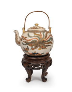 SATSUMA fine quality antique Japanese earthenware teapot with phoenix decoration, with carved wooden stand, Meiji Period, 19th century, 12cm high including handle, 19.5cm overall.