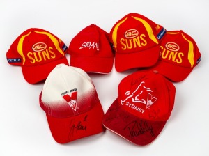 Three Sydney Swans caps, one with five original player signatures including Paul Kelly, and one with original signature of Barry Hall, together with three G.C. Suns caps.