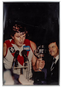 Two framed photographs of Barry Round winning the 1982 Escort Cup with Alan Aylett in background, 52.5 x 70.5cm overall, plus 'September 24th 2005 AFL Grand Final Sydney Swans versus West Coast Eagles' photo montage, framed and window mounted, 56 x 43cm o