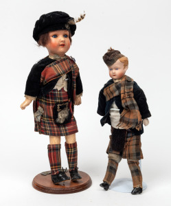 Two antique porcelain headed dolls in Scottish highland regalia, the larger by Armand Marseille, 36cm and 30cm high