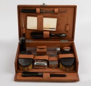 A travelling vanity set with ebony and silver plated accessories housed in a fitted tan leather case, 19th/20th century, the case 28cm wide - 2