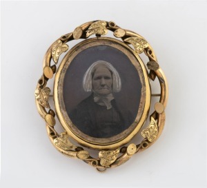 An antique pinchbeck brooch with double-sided ambrotype photo portraits, 19th century, 7cm high