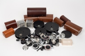 BOLEX-PAILLARD: An accumulation of more than fifty camera parts (cranks, spools, caps, etc.) and leather lens cases. (50+ items)