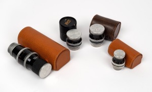 BOLEX-PAILLARD: Group of four lenses with Kern Paillard front and rear lens caps - one Yvar 25mm f2.5, one Switar AR 25mm f1.4, one Pizar AR 26mm f1.9, and one Yvar 75mm f2.8. (4 items)