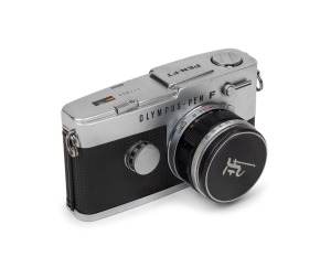 OLYMPUS: Pen-FT half-frame SLR camera [#317899] with F. Zuiko Auto-S 38mm f1.8 lens [#235477], Olympus lens cap, and Olympus-Pen F leather case, c. 1969.