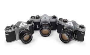 ASAHI KOGAKU: Group of three cameras - one Pentax SV with Super-Takumar 55mm f1.8 lens, one Pentax SP with Super-Takumar 50mm f1.4 lens, and one Pentax SL with Super-Takumar 50mm f1.4 lens. (3 items)