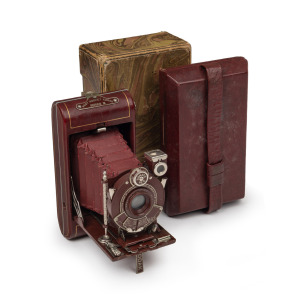KODAK: Vanity Kodak folding 127 film camera in red with Kodak Anastigmat 83mm f6.3 lens [#41654], matching satin-lined case, maker's box, and Kodak leather case, c. 1930. Special coloured version of the Vest Pocket Kodak Series III.