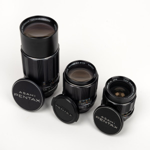 ASAHI KOGAKU: Group of three M42 SMC Takumar lenses, each with Pentax front and rear caps - one 35mm f2, one 120mm f2, and one 200mm f4. (3 items)