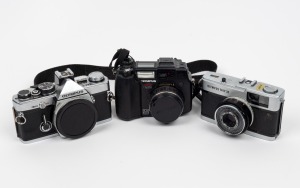 OLYMPUS: Group of three cameras - one Olympus Trip 35, one Olympus OM-2 (body only), and one Olympus Camedia C-5050. (3 items)