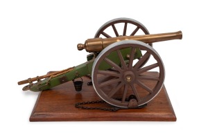Miniature cast bronze working model cannon on green painted timber stand, 20th century, the barrel 31cm long, 51cm long overall