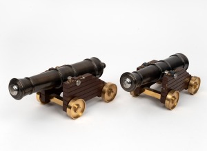 A pair of bronze cannon ornaments with timber carriages and brass wheels, 20th century, the barrels 27cm long