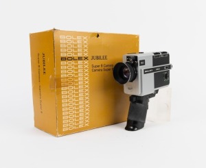 BOLEX-PAILLARD: Jubilee Super 8 movie camera, c. 1977, in maker's box with instruction booklet, remote control, and wrist strap attachment.