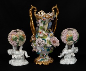 An antique English soft paste porcelain vase with applied floral decoration, together with a pair of Schneeballen German porcelain cherub vases, 19th century, (3 items), ​​​​​​​26cm and 15cm high.
