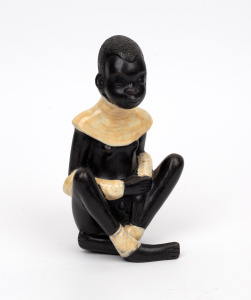 LEOPOLD ANZENGRUBER Austrian porcelain statue of a seated Nubian boy, mid 20th century, stamped "ANZENGRUBER, MADE IN VIENNA", 18.5cm high.