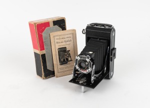 KODAK: Six-20 620 film camera [#40838], in black with enameled metal Art Deco faceplate, instruction booklet, and original maker's box, c. 1933.