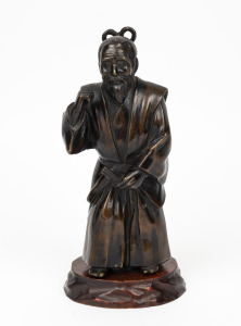A vintage Japanese cast bronze statue of a man standing on a carved timber base, 20th century, 25cm high overall
