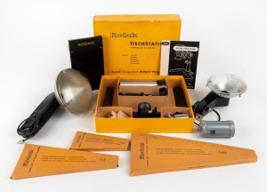 KODAK: Eight accessories - one Retina Table Stand in maker's box with all elements present, instruction booklet, and three supplementary lenses, together with two flash units with sync cables, three different focusing guide sets in maker's boxes, one 70mm metal film cassette, and one sheet film cassette. (8 items)