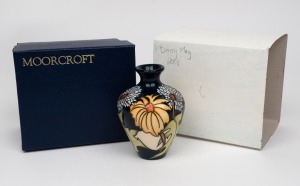 MOORCROFT "Daisy May" English pottery vase on dark green ground, in original box of issue, circa 2008, factory mark and artist's details to base, 10cm high.