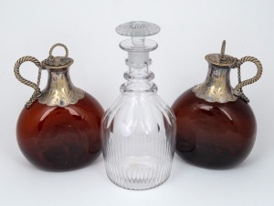A fine pair of antique amber glass decanters with silver plated mounts and stoppers; together with an Irish crystal three ring decanter with target stopper, 18th/19th century, (3 items), 20cm and 24cm high