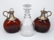 A fine pair of antique amber glass decanters with silver plated mounts and stoppers; together with an Irish crystal three ring decanter with target stopper, 18th/19th century, (3 items), 20cm and 24cm high