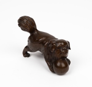 A Chinese cast bronze statue of a Pekingese dog with a ball, 20th century, ​​​​​​​7cm high, 10cm long