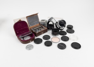 CANON: An accumulation of twenty-one Canon camera accessories, including three different Auto-Up attachments, four lens hoods, eleven lens caps, and others. (21 items)