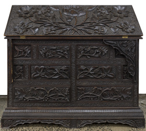 An Anglo-Indian padouk bureau, ornately carved with opium poppies and flowers, 19th century, 88cm high, 95cm wide, 50cm deep.