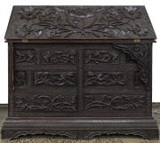 An Anglo-Indian padouk bureau, ornately carved with opium poppies and flowers, 19th century, 88cm high, 95cm wide, 50cm deep.