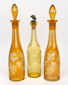 Three antique citrine overlaid cut glass decanters, 19th century, the largest 41cm high