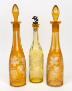 Three antique citrine overlaid cut glass decanters, 19th century, the largest 41cm high