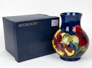 MOORCROFT "Hibiscus" English baluster shaped pottery vase on blue ground, impressed factory mark "Moorcroft, Made in England" with original paper label "By Appointment, W. Moorcroft, Pottery to the late Queen Mary", 25cm high