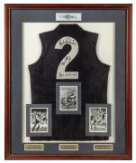 CARLTON limited edition No.2 guernsey, signed by GREG WILLIAMS, JOHN NICHOLS, and PETER MOTLEY, attractively framed and glazed with black and white action photographs of each player. ​​​​​​​109 x 89cm overall.