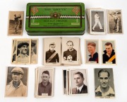 An accumulation of sporting cigarette & trade cards all contained in a vintage "The Greys" Drapkin Tobacco tin; subjects include cricket, Australian Rules Football, Rugby, Boxing, etc. (60+). Mixed condition.