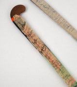 A Vijayanti hockey stick with applied fabric, signed by the 1998 Indian hockey team, who were competing in Australia, together with another hockey stick with many signatures illegible. - 2