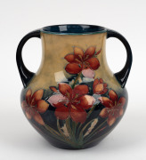 MOORCROFT "Protea" rare twin-handled English pottery vase, finely decorated with large protea flowers and the reverse decorated with a spray of African Lilies, circa 1928, impressed signature mark to base "W. Moorcroft, Potter to H. M. The Queen. Made in - 2