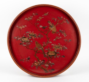 An antique Japanese red lacquered serving tray with hand painted birds and blossoms, Meiji Period 19th/20th century, 71.5cm diameter