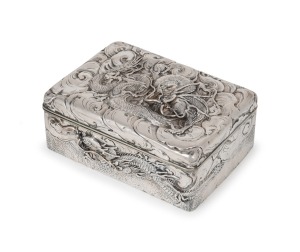 An antique Japanese export silver box decorated with dragons and clouds, Meiji Period, 19th century, 6cm high, 15.5cm wide, 11cm deep, 524 grams.