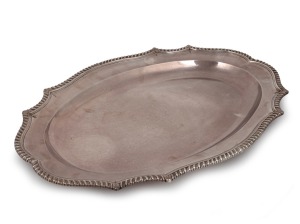 A Georgian sterling silver serving tray with gadrooned border and engraved pictorial crest, made by John Wakelin & William Taylor of London, circa 1783, 56.5cm wide, 3712 grams.