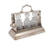 An antique English silver plated three bottle tantalus of diminutive size, stamped "THE TANTALUS, BETJEMANS PATENT, LONDON", 19th century, 20cm high, 23cm wide.