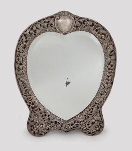 An antique English sterling silver framed heart shaped table mirror, made for Thomas Webb of Melbourne, Birmingham, circa 1902, 42 x 33cm.