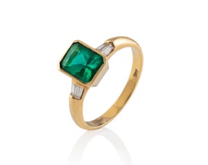 An 18ct gold and greenstone ring flanked by diamonds on each shoulder, 20th century, stamped "18K", 5 grams total