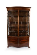 A handsome antique English Sheraton Revival bow fronted mahogany display cabinet with astragal glazed doors, late 19th century, 223cm high, 135cm wide, 40cm deep.